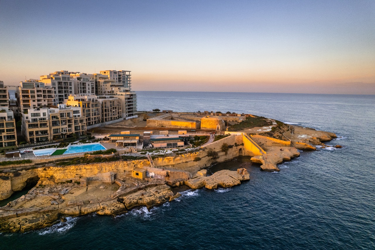 Sliema seaside resort in Malta at sunset, blue ocean waters, aerial drone view Sliema seaside resort in Malta at sunset, blue ocean waters, aerial drone view.